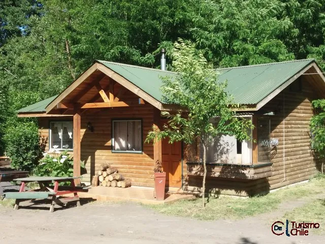 Cabaña grande con techo verde y mesa de picnic en Rucalhue Saltos del Laja
