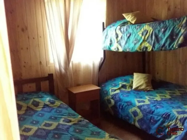 Dormitorio con camarote y camas individuales en cabaña familiar de Rucalhue